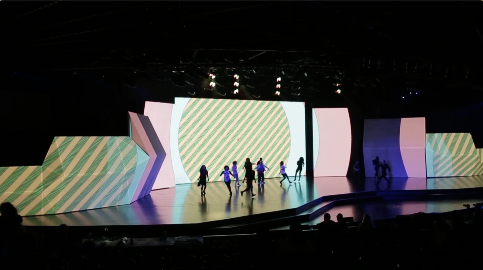 Performers on a stage lit with large digital projections at Google Brandcast